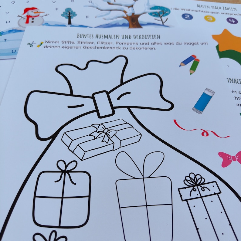 Op de afbeelding: Een zwart-witte illustratie van een cadeauzak met een strik erbovenop. De zak is gevuld met drie ingepakte cadeaus. De tekst "BUNTES AUSMALEN UND DEKORIEREN" staat bovenaan de afbeelding. De tekst "Nimm Stifte, Sticker, Glitzer, Pompons und alles was du magst um deinen eigenen Geschenkesack zu dekorieren." staat onder de afbeelding.