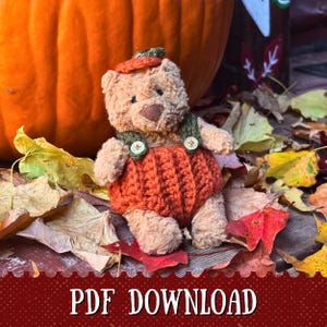 May include: A teddy bear in an orange pumpkin outfit, green straps, and a hat, set amongst autumn leaves and a large pumpkin. The text "PDF DOWNLOAD" is visible. The scene evokes a cozy autumnal theme.