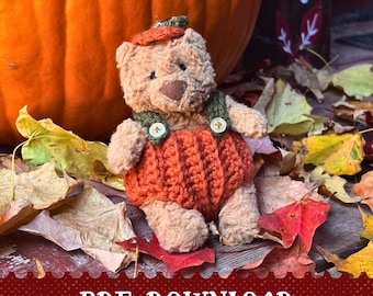 May include: A plush teddy bear wearing an orange pumpkin costume with green suspenders and a matching hat. The bear is surrounded by autumn leaves and a large orange pumpkin. The text "PDF DOWNLOAD" is at the bottom.