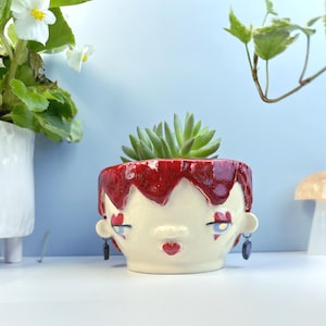 Queen of Hearts Head Planter – Handmade Ceramic Face Pot with Red Hair & Gold Eyes, Unique Garden Decor or Valentine’s Gift