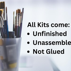 K&ouml;nnte beinhalten: Nahaufnahme eines Sets Pinsel in einem durchsichtigen Glasgef&auml;&szlig;. Der Text lautet "Alle Kits werden geliefert: Unvollendet, Unmontiert, Nicht geklebt".