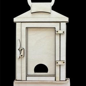 May include: A wooden lantern with a handle, door, and a semi-circular opening at the bottom. The lantern is made of light-colored wood and has a simple, rustic design. The door is closed with a latch.