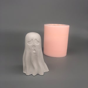 May include: A white ghost-shaped silicone mold for making candles or soap. The mold is next to a finished white ghost candle.