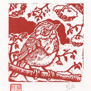 Peut inclure: Une linogravure rouge et blanche représentant un oiseau perché sur une branche, entouré de feuilles et de baies. L'oiseau est détaillé avec des lignes texturées. L'impression comprend des caractères chinois et les initiales de l'artiste.
