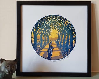 May include: Framed art print featuring a stylized illustration of a cat walking down a path lined with trees. The artwork is in a circular design with blue, yellow, and orange hues. The frame is black.