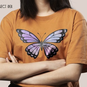 May include: A mustard yellow t-shirt with a purple and black butterfly graphic print.