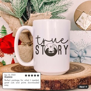 K&ouml;nnte beinhalten: Wei&szlig;e Keramik-Kaffeetasse mit einem schwarzen Design, das "true STORY" sagt, mit einer Silhouette der Weihnachtsgeschichte in einem Kreis.