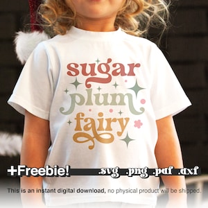 May include: A white t-shirt with a colorful graphic design that says "sugar plum fairy" with stars and glitter. The text is in a retro font style. The image includes the text "+Freebie! .svg .png .pdf .dxf".