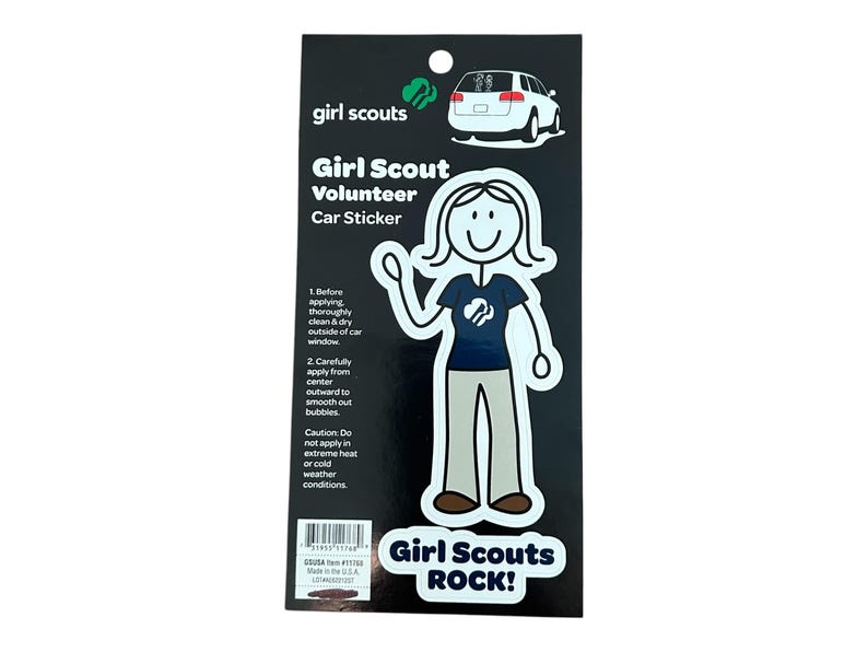 May include: A black and white sticker featuring a stick figure of a Girl Scout volunteer wearing a blue shirt with the Girl Scout logo. The sticker says "Girl Scout Volunteer Car Sticker" and "Girl Scouts ROCK!"