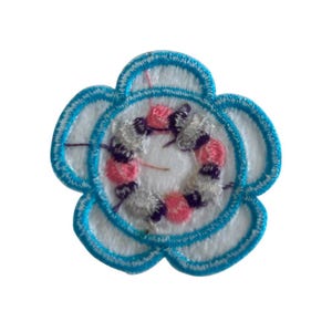 May include: A blue flower-shaped embroidered patch with a white center and a pink and gray swirl design.
