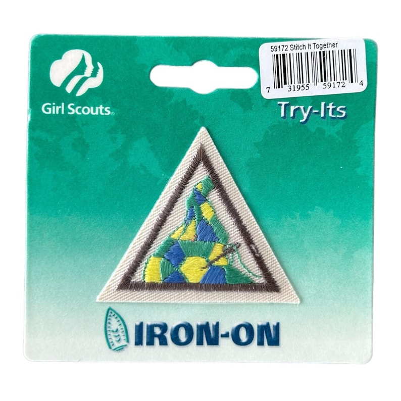 May include: Girl Scout Try-Its iron-on patch featuring a triangular design with a colorful, stitched-together quilt inside. The patch is brown, white, green, yellow, and blue.