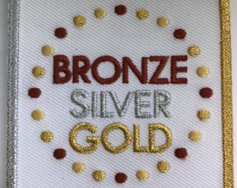 Écusson amusant en triple métal, bronze, argent et or, ambassadrices pour personnes âgées