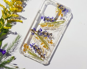 May include: A clear phone case with pressed lavender and yellow flowers. The flowers are arranged in a diagonal pattern.