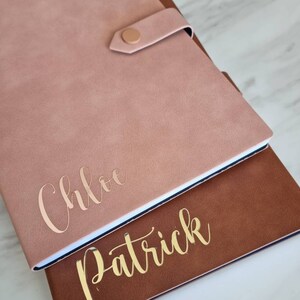 May include: Two personalized journals with gold lettering. The top journal is pink with the name "Chloe" and the bottom journal is brown with the name "Patrick".