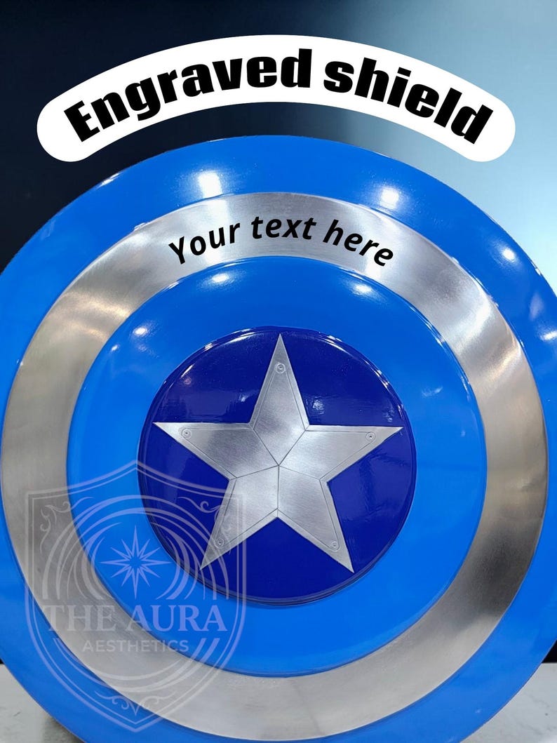 May include: A blue and silver shield with a large silver star in the centre. The shield has the text "Engraved shield" and "Your text here". The logo "THE AURA AESTHETICS" is at the bottom.