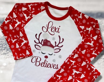 Personalised Embroidered Christmas Childrens Pyjamas and Rompersuits with a Gorgeous Winter Reindeer and the Words 'Believes' under the Name