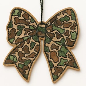 May include: A decorative bow-shaped ornament with a camouflage pattern in shades of brown, green, and tan. The bow has a textured appearance and is suspended by a dark green string, suitable for holiday or rustic decor.