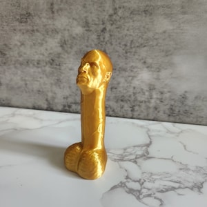 May include: A gold-colored, 3D printed sculpture of a human head and torso.