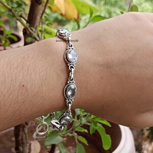 Könnte beinhalten: Ein silbernes Armband mit ovalen, klaren Edelsteinen. Das Armband hat eine dekorative, seilartige Umrandung um jeden Edelstein und ist durch kleine Silberglieder verbunden. Der Text "Silverjewellery30" ist sichtbar.
