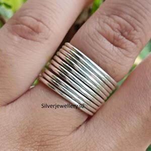 Könnte beinhalten: Ein Satz stapelbarer Silberringe. Die Ringe sind dünn und haben eine polierte Oberfläche. Das Bild zeigt die Ringe an einem Finger. Der Text "Silverjewellery30" ist auf dem Bild sichtbar.