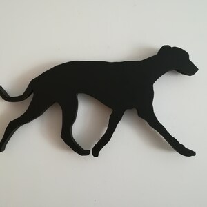 May include: Black silhouette of a dog running, cut out of wood.