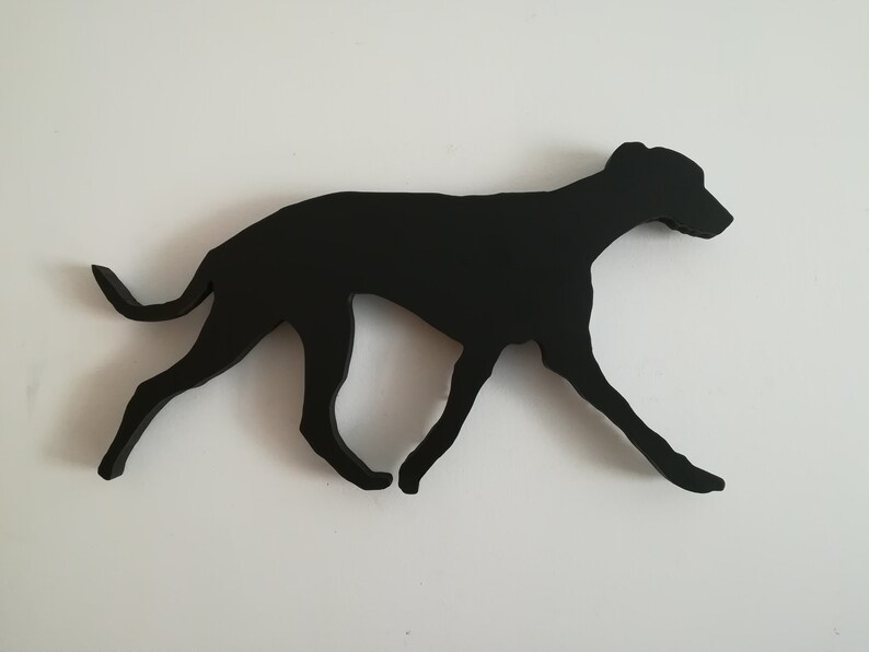 May include: Black silhouette of a dog running, cut out of wood.