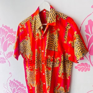 May include: A red and pink short-sleeved button-up shirt with a tiger print.