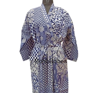 Könnte beinhalten: Eine blaue und weiße gemusterte Baumwollrobe mit einem Bindegürtel. Die Robe hat ein Patchwork-Design mit verschiedenen geometrischen und floralen Mustern.