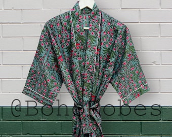 May include: A teal blue cotton robe with a floral print in shades of pink and green. The robe has a white trim and a tie belt.