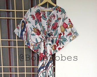 May include: White cotton robe with a floral print featuring birds and leaves in shades of red, blue, and green. The robe has a tie at the waist and a V-neck.