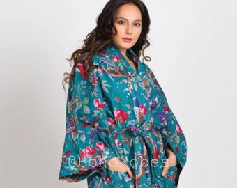 Puede incluir: Bata con estampado floral turquesa con cinturón anudado y bolsillos. La bata presenta un vibrante estampado de flores y pájaros rojos, rosas y azules. El texto "@BohoRobes" es visible en la bata.