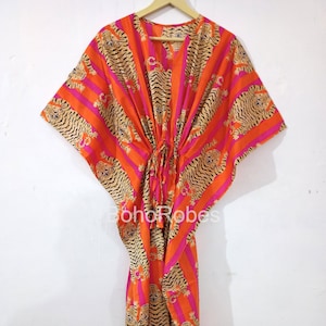 May include: Orange and pink striped kaftan with a tiger print. The kaftan has a drawstring waist and is made of a soft, flowing fabric.