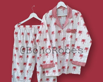 May include: White pajamas with a red palm tree print. The top has a button-up collar and long sleeves. The pants have an elastic waistband.