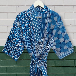 May include: A blue and white patterned cotton robe with a tie belt. The robe has a variety of geometric and floral patterns.