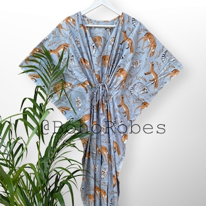 May include: A light blue kaftan with a print of deer, raccoons, and foxes. The kaftan has a drawstring waist and long sleeves.