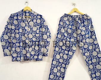Puede incluir: Conjunto de pijama de estampado floral azul y blanco con una parte superior con botones y pantalones largos.