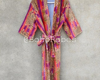 May include: A long, purple and orange striped robe with a tiger print. The robe has a sash tie and is hanging on a white hanger.