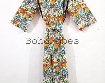 May include: White cotton robe with a colorful print of zebras, leopards, and flowers. The robe has a tie belt and long sleeves.