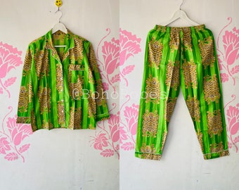 May include: Green and yellow striped pajama set with a tiger print. The top has a button-up front and long sleeves. The pants have a drawstring waist.