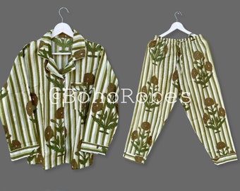 May include: A green and white striped pajama set with a floral print. The top has a button-up closure and long sleeves. The pants have an elastic waistband.