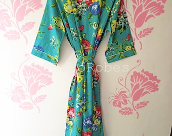 May include: A turquoise blue robe with a floral print featuring pink, yellow, and blue flowers. The robe has a white trim and a tie belt.