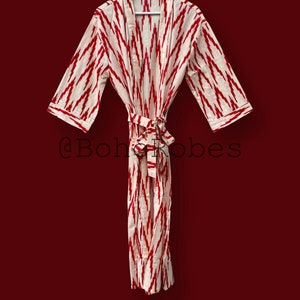 May include: A white and red patterned robe with a tie belt. The robe has a traditional kimono style. The text "@boho_robes" is visible in the image.