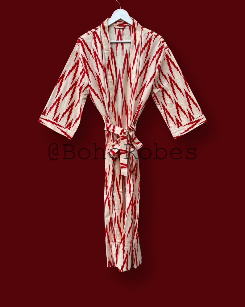 May include: A white and red patterned robe with a tie belt. The robe has a traditional kimono style. The text "@boho_robes" is visible in the image.