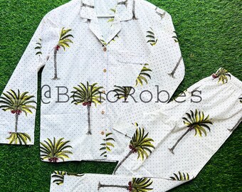 Peut inclure: Ensemble pyjama blanc avec un imprimé palmier et des pois blancs. Le haut a un devant boutonné et des manches longues. Le pantalon a une taille élastique.