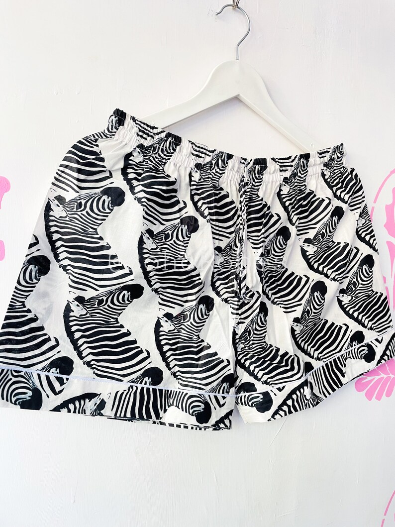 May include: White cotton shorts with a black and white zebra print.