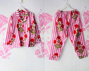 May include: Pink and white striped pajama set with red floral print. The top has a button-up collar and long sleeves. The pants have a relaxed fit.