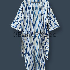 May include: A white and blue patterned robe with a long sleeve and a tie belt. The robe has a chevron pattern in blue on a white background.