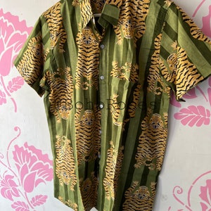 May include: A green and orange short-sleeved button-up shirt with a tiger print pattern.