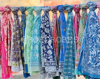 May include: A collection of colorful patterned scarves hanging on a line. The scarves are made of cotton and have a variety of floral and geometric designs.