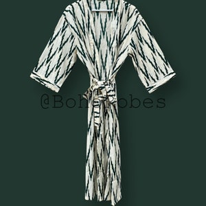 May include: A white and green patterned robe with a tie belt. The robe has a traditional kimono style with long sleeves and a relaxed fit.